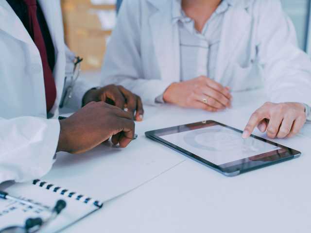 doctor sitting at table examining test results