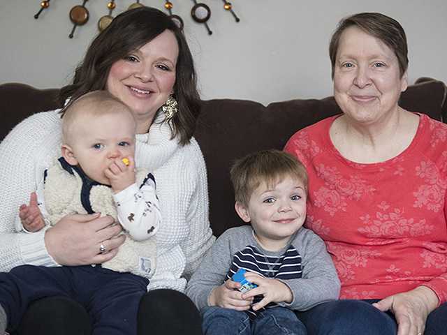 grandmother, mother, and two children sitting on a couch