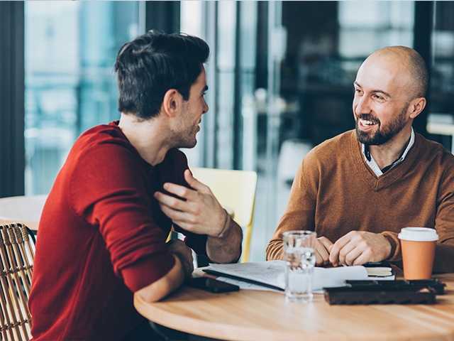 Two man talking over coffee.