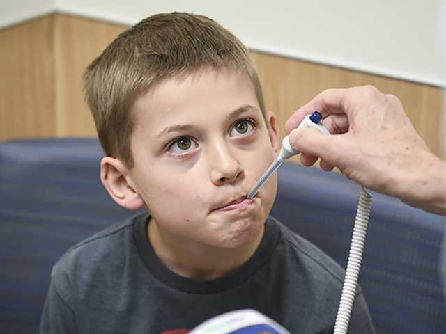 Young boy getting temperature taken.