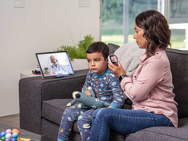 woman sitting on couch with sick little boy