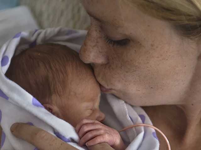 Mother kissing baby's forehead