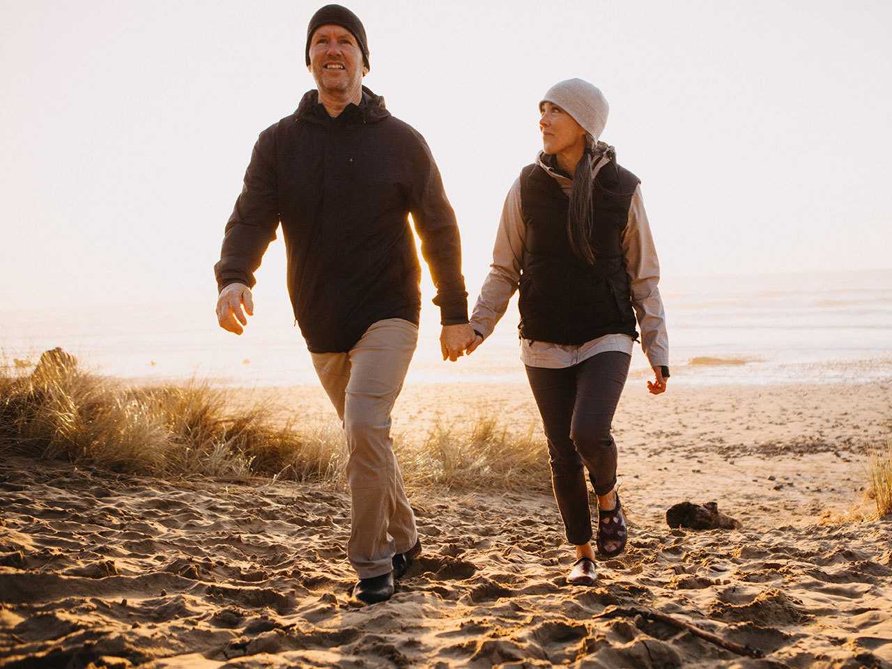 Man and woman walking on the beach.