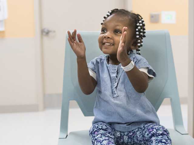 Young child clapping their hands.