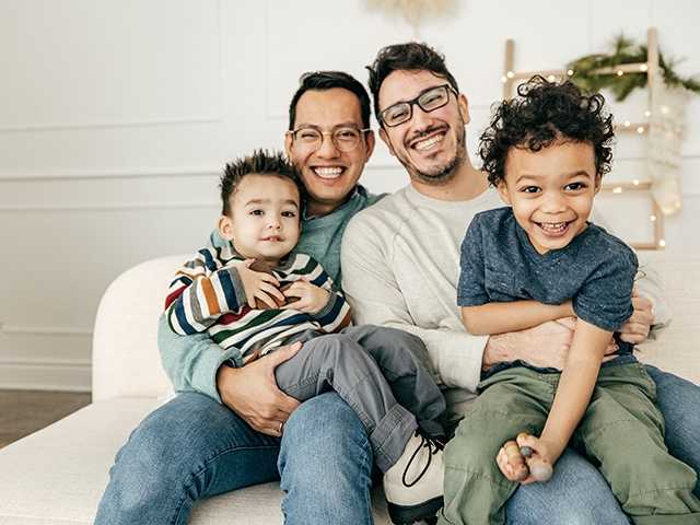 Couple holding two children on their lap.